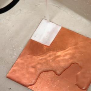 Rinsing the copper board to soak the paper